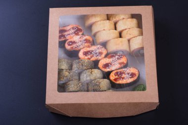 Japon mutfağından deniz ürünleri ve peynirli börekler teslimat için kutuda.