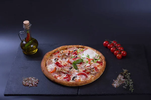 Włoska Pizza Pomidorami Papryką Mięsem Leży Obok Dzbanka Przypraw Ciemnym — Zdjęcie stockowe