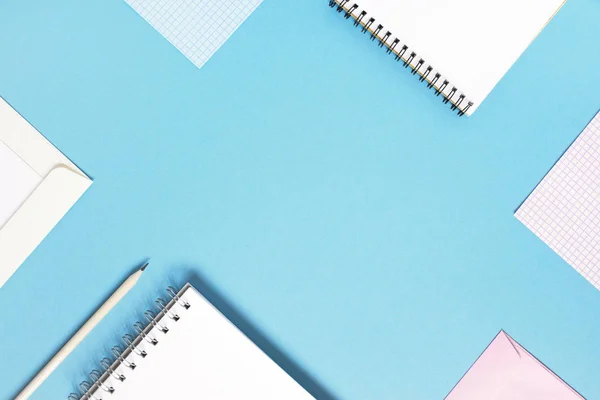 Blue background with notepads, check sheets and envelopes