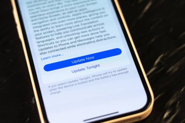 KYIV, UKRAINE - September 15, 2025 : Modern smartphone Apple iPhone with system update purpose. New ios 26 with liquid glass effect.