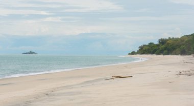 Düşük tide, aksi takdirde boş bir plaj Panama kenarında dururken su braving uzak yalnız kız contemplates.
