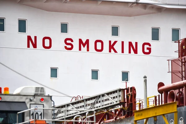 危険な習慣は 大きな大きな海行く船の橋の上の赤文字記号を描いた指示乗組員なし禁煙 — ストック写真