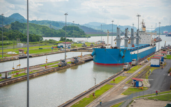 Large cargo ships pass through the Panama Canal locks.  This everyday event, provides income from both fees, and tourism, for the whole country. 