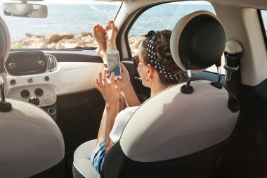 Genç kadın gezgin Gps navigator telefonunu kullanarak araba.
