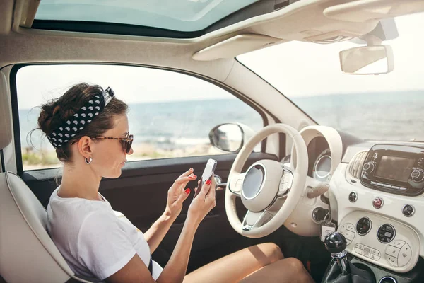 Genç kadın gezgin Gps navigator telefonunu kullanarak araba.