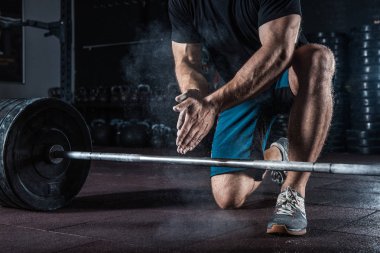 Spor arka plan. Genç atlet ağırlık kaldırma eğitim için hazırlanıyor. Powerlifter el eğitim için Talk hazırlanmasında