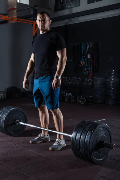 肌肉健身男子摆在健身房站立在杠铃前运动 — 图库照片