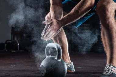 Spor arka plan. Genç atlet ağırlık kaldırma eğitim için hazırlanıyor. Powerlifter el eğitim için Talk hazırlanmasında