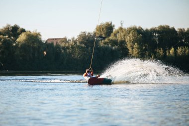 Adam sürme wakeboard göl kenarında