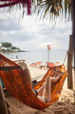 Genç ve güzel kadın onu tatil sırasında bir hamak sahilde rahatlatıcı