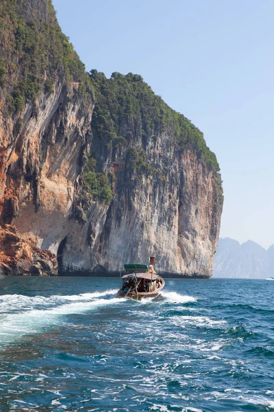 Long tail boat on the sea with rock on background