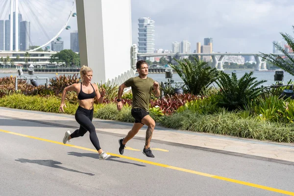 Junges Fitness-Paar läuft im Stadtgebiet — Stockfoto