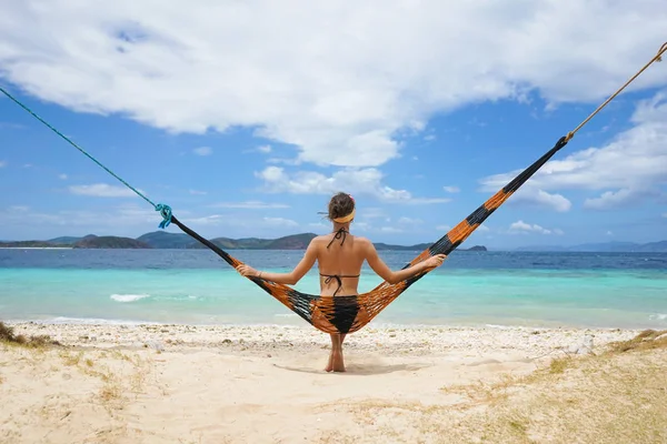 Vrouw ontspannen aan het strand op een hangmat — Stockfoto