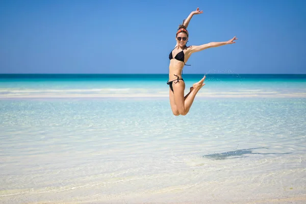 Retrato de bela jovem pulando no ar na praia . — Fotografia de Stock