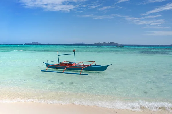 Um pequeno barco azul em uma praia tropical — Fotografia de Stock