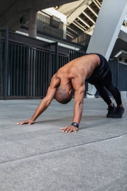 Genç kaslı sporcu antrenmandan önce esneme hareketleri yapıyor.. 