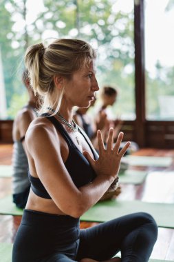 Yoga dersinde birlikte meditasyon yapan insanlar..