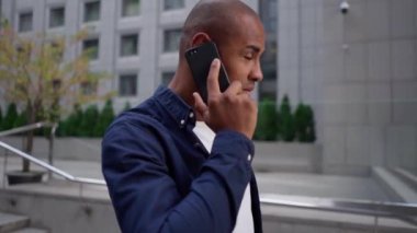 Yakışıklı, Afro-Amerikalı bir adam cep telefonuyla konuşuyor.