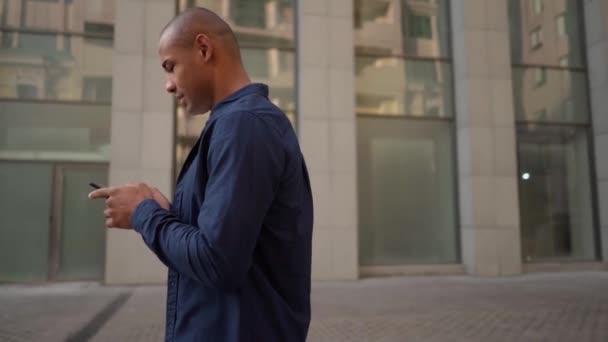 街を歩いて携帯電話で楽しい会話をしている男 — ストック動画