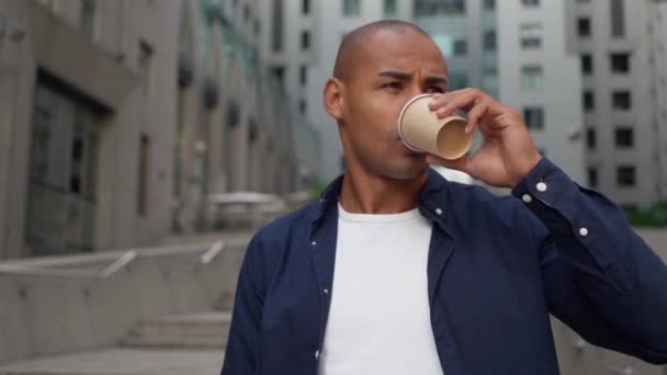 Красивий молодий бізнесмен п'є каву за допомогою смартфона — стокове відео