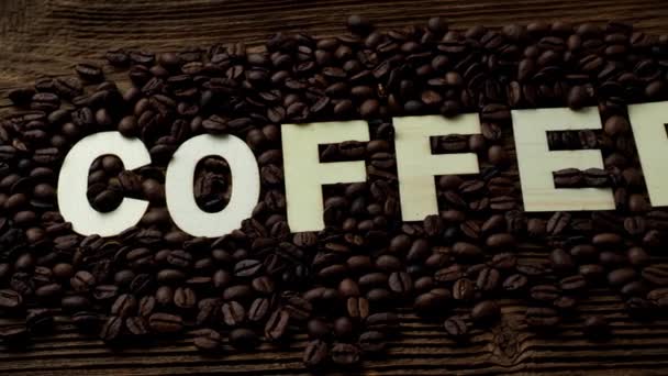 Czarna Kawa Ziarna Leżą Brązowy Drewniany Stół Słowo Kawy — Wideo stockowe