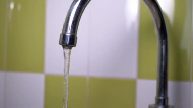Musluktan su dökülüyor. Mutfaktaki muslukta su jeti basıncı..