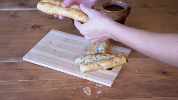 Donna rompe pasticcini croccanti freschi con le mani sul tavolo. Primo piano. — Video Stock