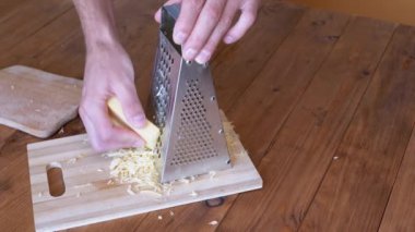 Man Hand, Metal Öğütücüye Sert Peynir Sürttü. Ev mutfağı. Yakın plan..