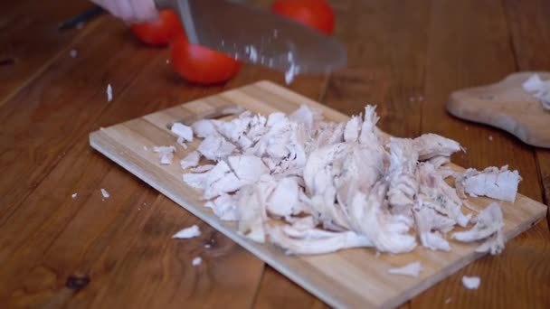 Eine Frauenhand schwingt kräftig ein Messer und hackt gekochtes Fleisch auf einem Holzbrett. — Stockvideo