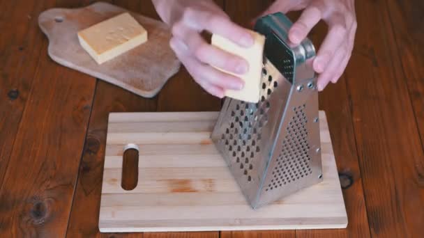 Womans Hand Rubs Hard Cheese op een Metal Grater. Huiskeuken. Close-up. — Stockvideo