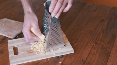 Man Hand, Metal Öğütücüye Sert Peynir Sürttü. Ev mutfağı. Yakın plan..