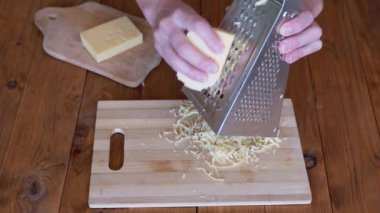 Kadınların Elleri Metal Öğütücüye Sert Peynir Sürttü. Ev mutfağı. Yakın plan..