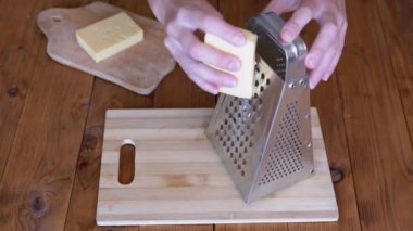 Kadınların Elleri Metal Öğütücüye Sert Peynir Sürttü. Ev mutfağı. Yakın plan..