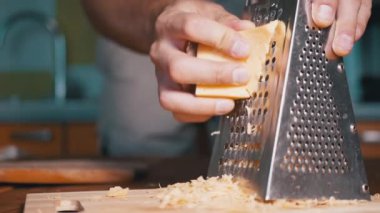 Man Hand, Metal Öğütücüye Sert Peynir Sürttü. Ev mutfağı. Yakın plan..