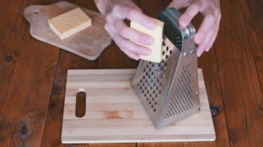 Kadınların Elleri Metal Öğütücüye Sert Peynir Sürttü. Ev mutfağı. Yakın plan..