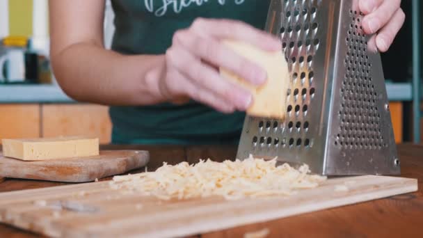 Womans Hand Rubs Hard Cheese on a Metal Grater. Home kitchen. Close-up. — Stock Video