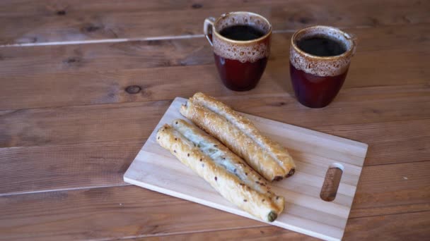 Thé parfumé et pâtisseries fraîches croustillantes sur une planche à découper. Gros plan. — Video