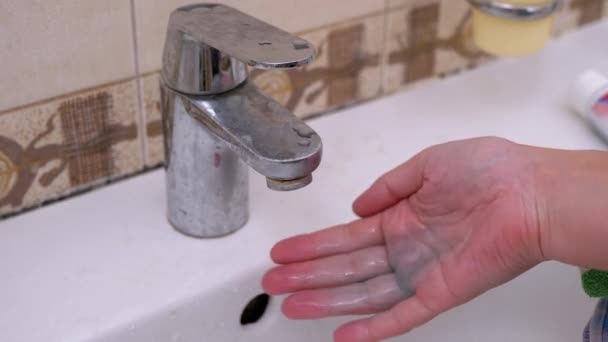 Femme allume le robinet d'eau et se lave les mains Savon liquide avec de la mousse. — Video