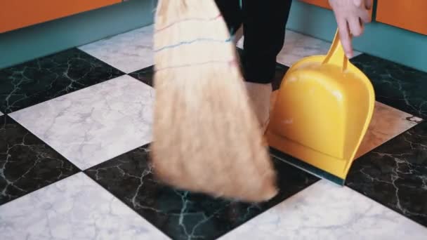 Funny Woman Dances and Sweeps Πάτωμα στις Κάλτσες στην κουζίνα με σκούφο και φτυάρι — Αρχείο Βίντεο
