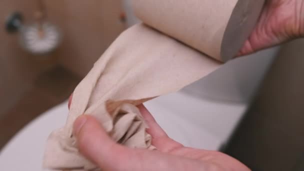 Żeńskie ręce zwijają się i rozrywają kawałek papieru toaletowego. Zbliżenie. Zwolniony ruch — Wideo stockowe