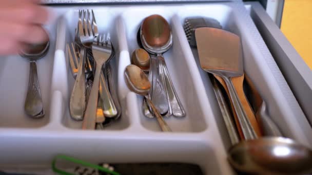 La mano femenina pone una cuchara y tenedores en la caja con cubiertos sucios en la cocina casera — Vídeos de Stock