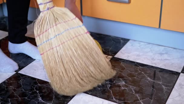 Mujer barrer piso de baldosas con escoba vieja y plato de polvo en la cocina moderna — Vídeo de stock