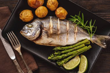 Dorado balık fırında patates, kuşkonmaz ve domates ile.