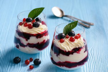 Berry mascarpone köpüğü tatlı, mavi arka plan.