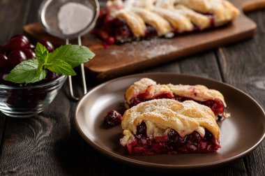 Ev yapımı kiraz puf böreği braid, mavi ahşap zemin üzerine.