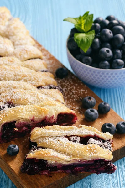 Ev yapımı yaban mersini puf böreği braid, mavi ahşap zemin üzerine.