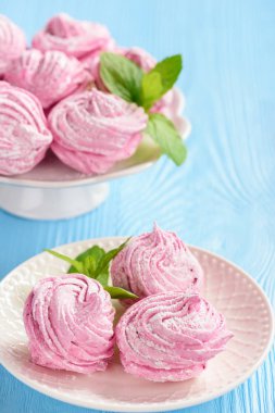 Ev yapımı berry zephyr veya marshmallow, mavi ahşap zemin üzerine.