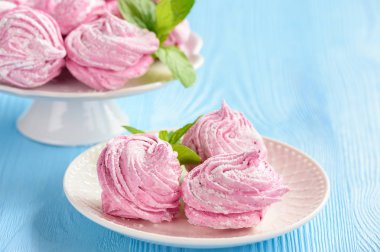 Ev yapımı berry zephyr veya marshmallow, mavi ahşap zemin üzerine.