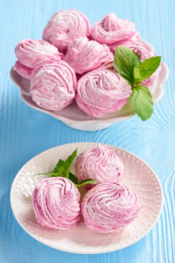 Ev yapımı berry zephyr veya marshmallow, mavi ahşap zemin üzerine.