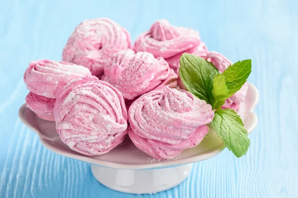 Ev yapımı berry zephyr veya marshmallow, mavi ahşap zemin üzerine.